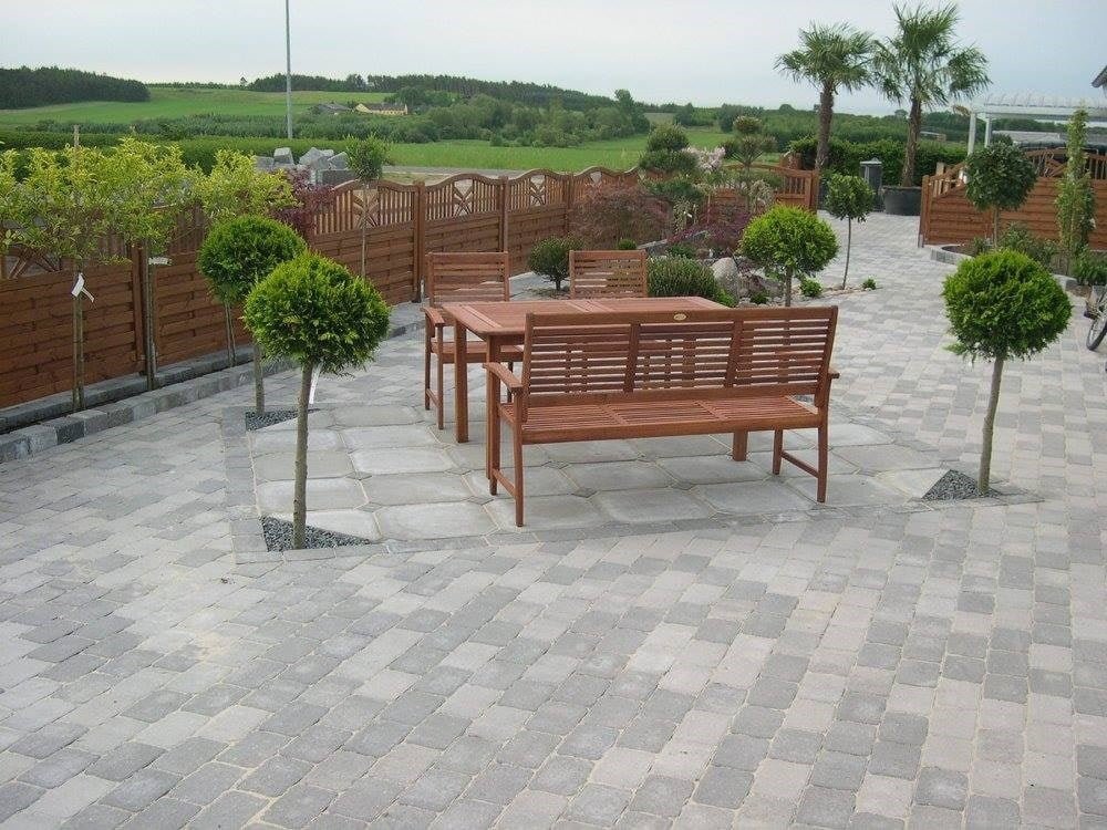 Brolagt terrasse med træmøbler og små træer