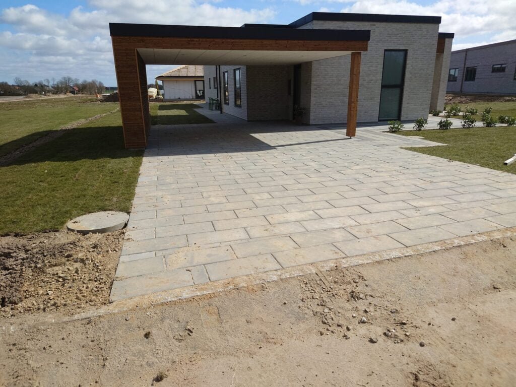 Moderne hus med flisebelagt indkørsel og carport